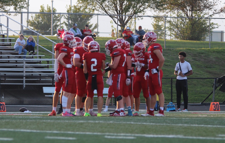 Members of the PHS football team huddle together as they discuss their next play.